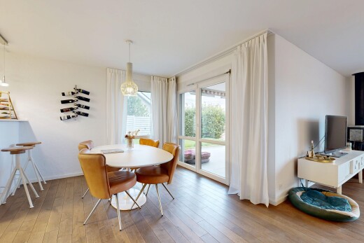 salle à manger avec sol en finition bois, wood finish floor, télévision, cloison sèche, et lumière naturelle