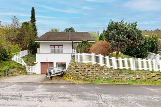 außenansicht mit zaun, balkon, eingebaute garage, auffahrt, und property visible