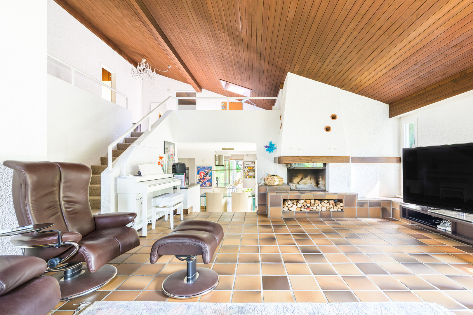 salon avec télévision, wood ceiling, plafond en bois, inside property, et escaliers
