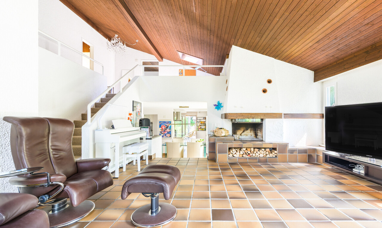 salon avec télévision, wood ceiling, plafond en bois, inside property, et escaliers