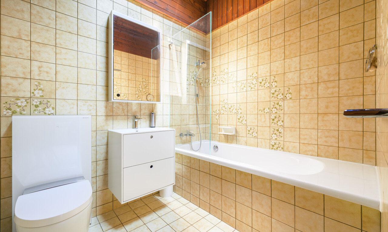 salle de bains avec tile wall, mur en carrelage, inside property, tile tub, et douche-bain combinés