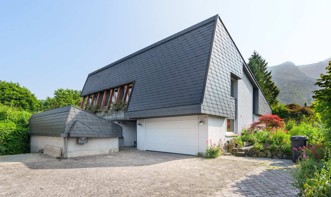 façade avec property visible, garage intégré, bardage en bardeaux, mountain view, et vue sur la montagne