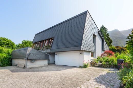 façade avec property visible, garage intégré, bardage en bardeaux, mountain view, et vue sur la montagne