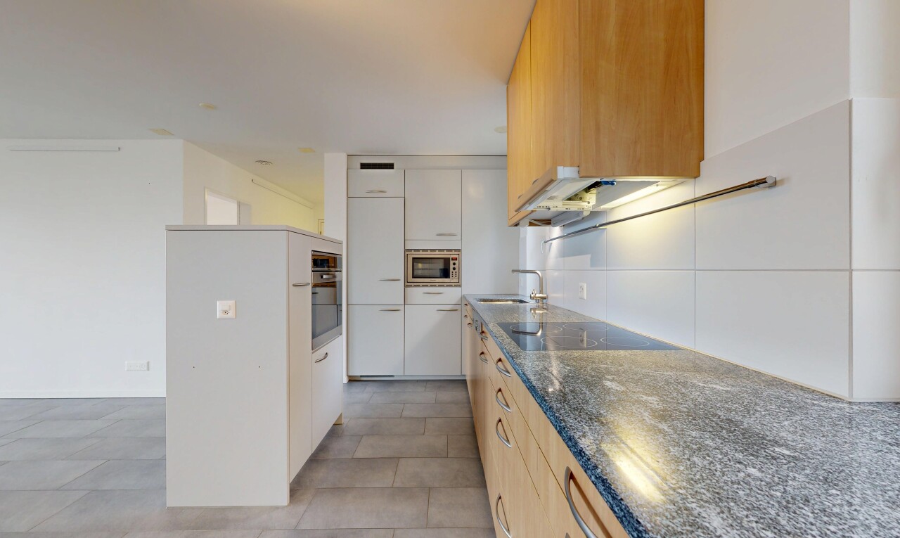 kitchen with dark stone countertops, stainless steel appliances, modern cabinets, and light wood finish cabinetry