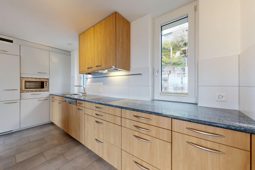 cuisine avec dark countertops, lumière naturelle, natural light, plans de travail en pierre, et stone countertops