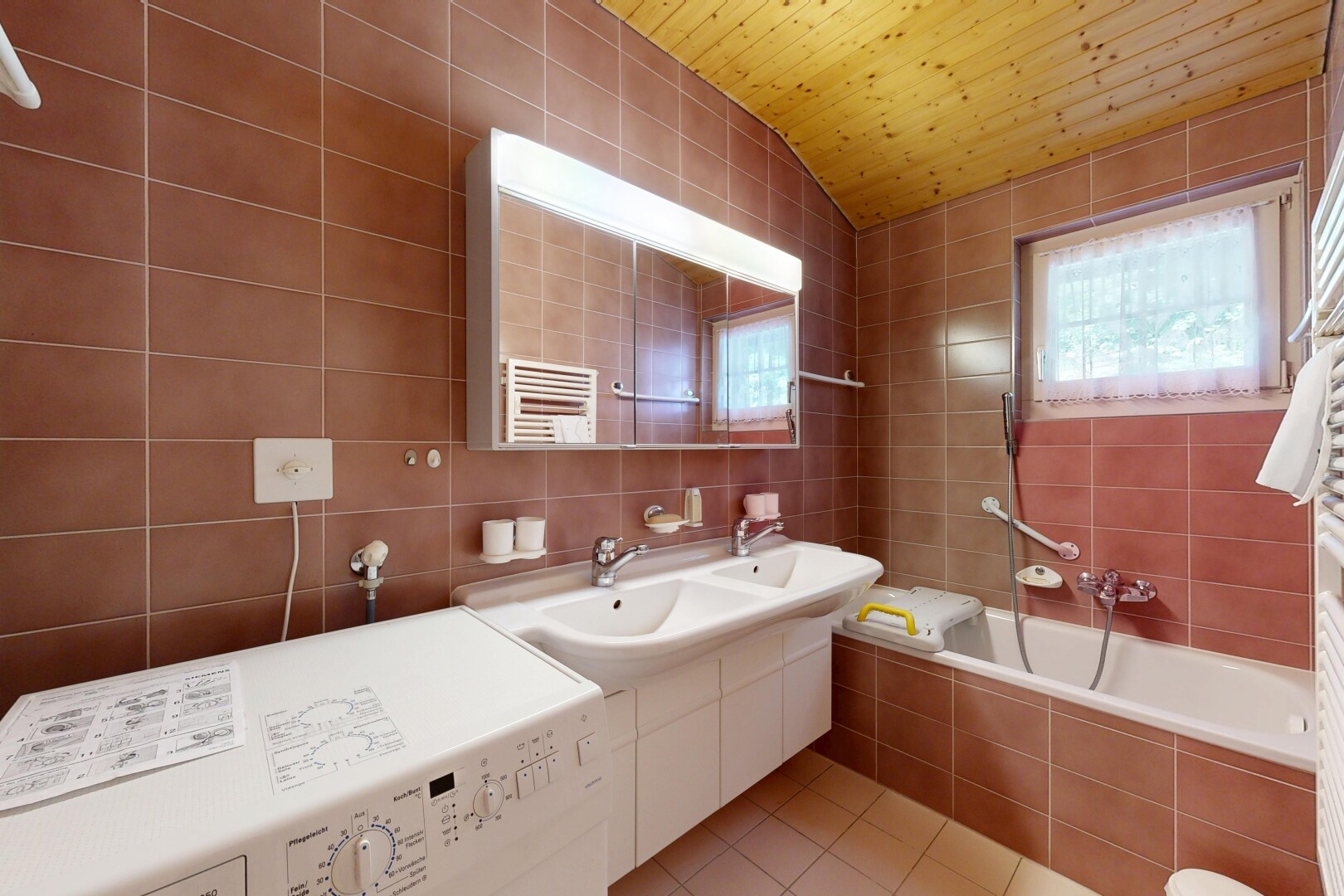 salle de bains avec tile wall, mur en carrelage, lave-linge et sèche-linge, salle de bain complète, et inside property