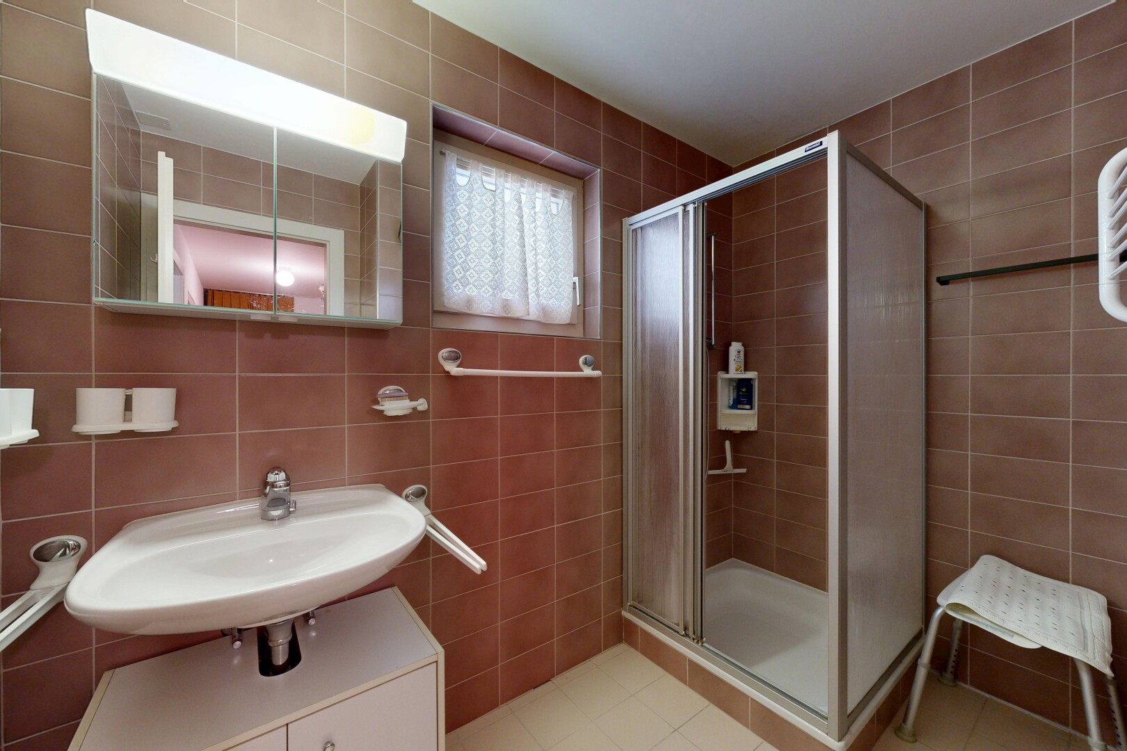 salle de bains avec mur en carrelage, tile wall, miroir, douche, et salle de bain complète