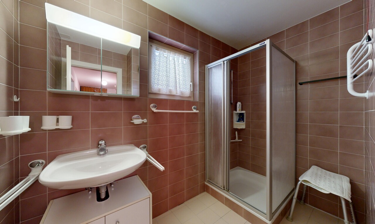 salle de bains avec mur en carrelage, tile wall, miroir, douche, et salle de bain complète
