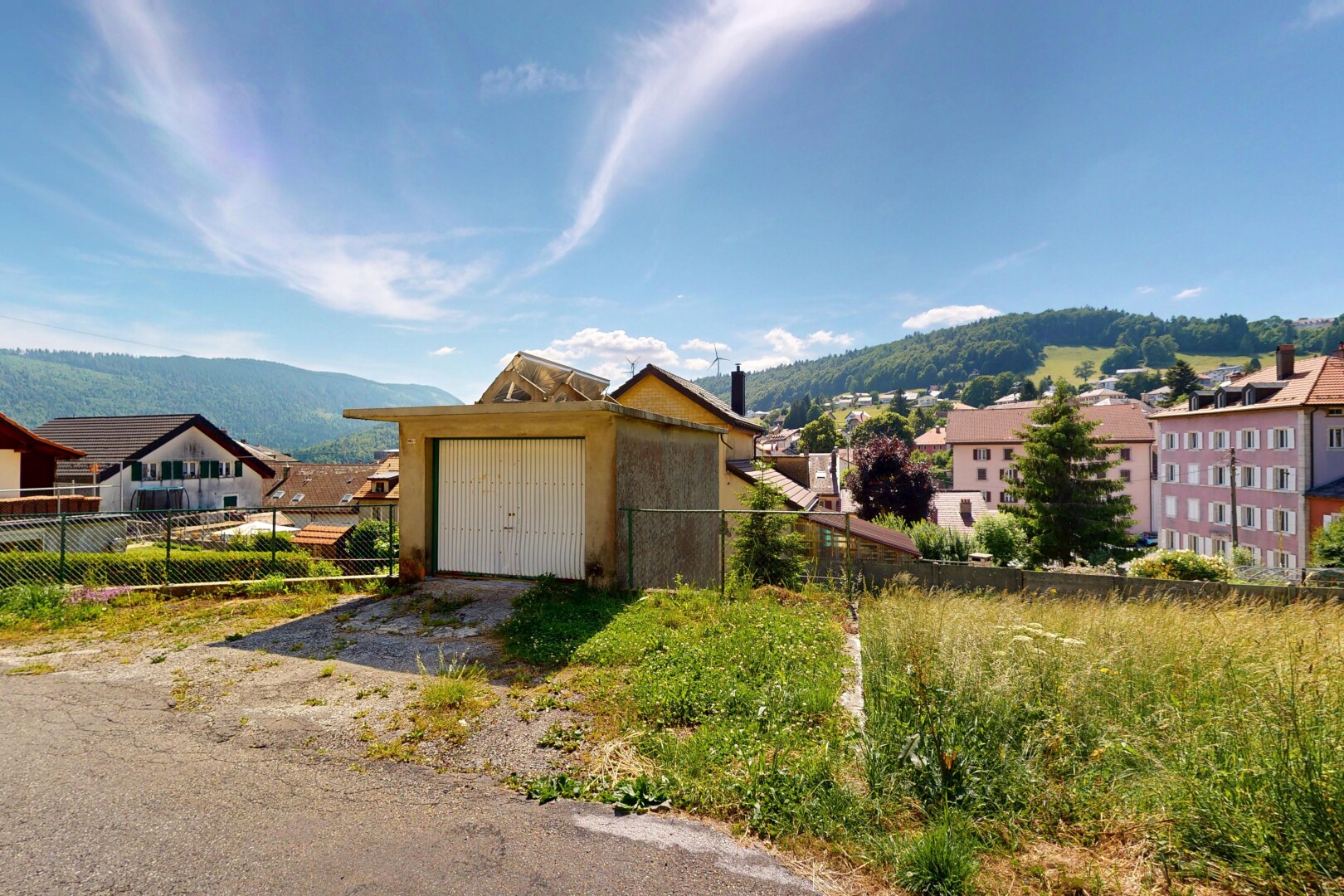 view of property with a garage, a mountain view, and driveway