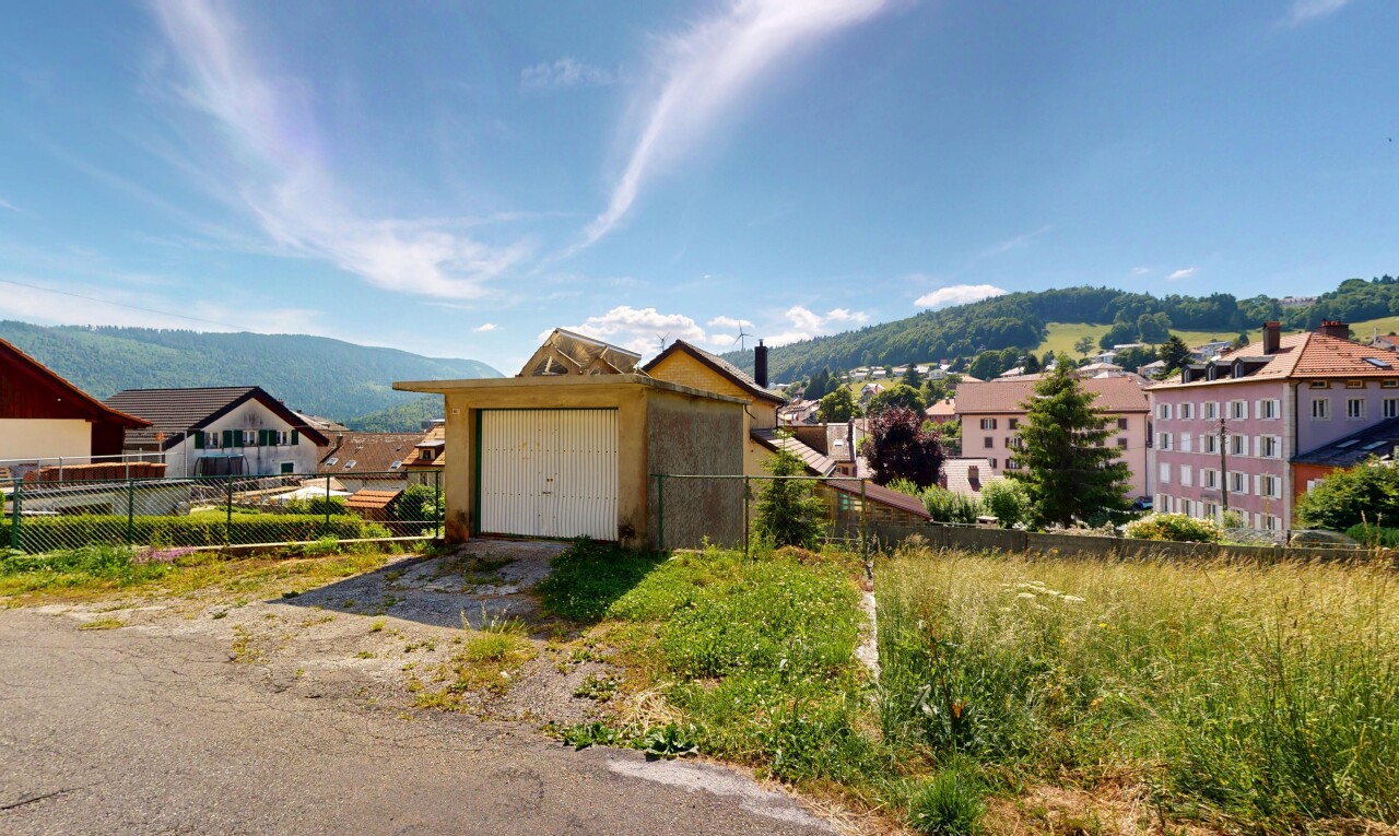 view of property with a garage, a mountain view, and driveway