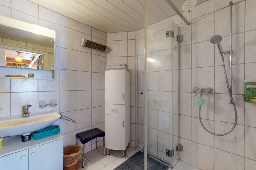 salle de bains avec mur en carrelage, tile wall, inside property, douche, et lavabo (ou coiffeuse selon le contexte)