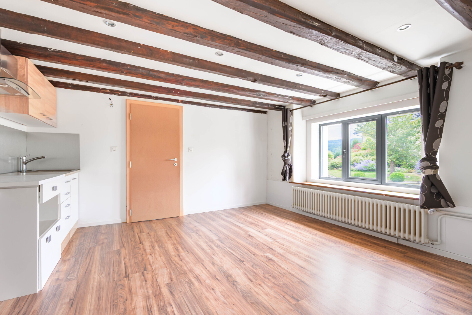 pièce vide avec natural light, lumière naturelle, inside property, radiateur, et wood finish floor