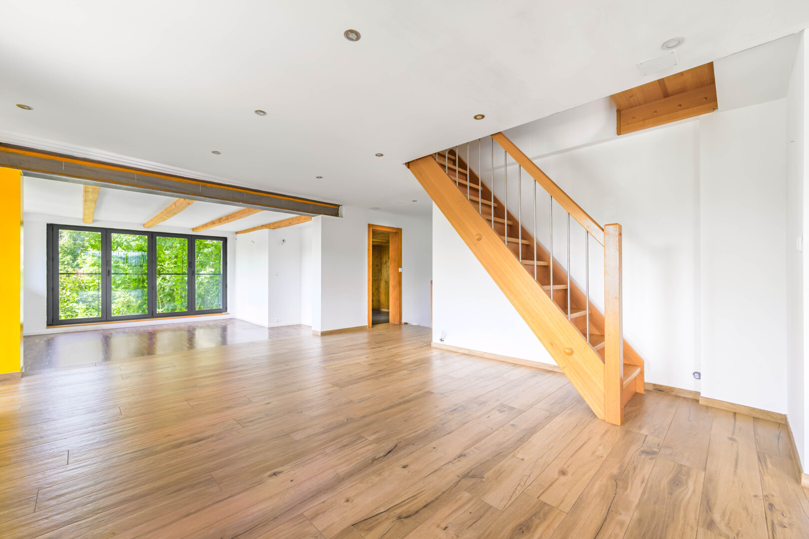 pièce vide avec wood finish floor, sol en finition bois, drywall, cloison sèche, et natural light