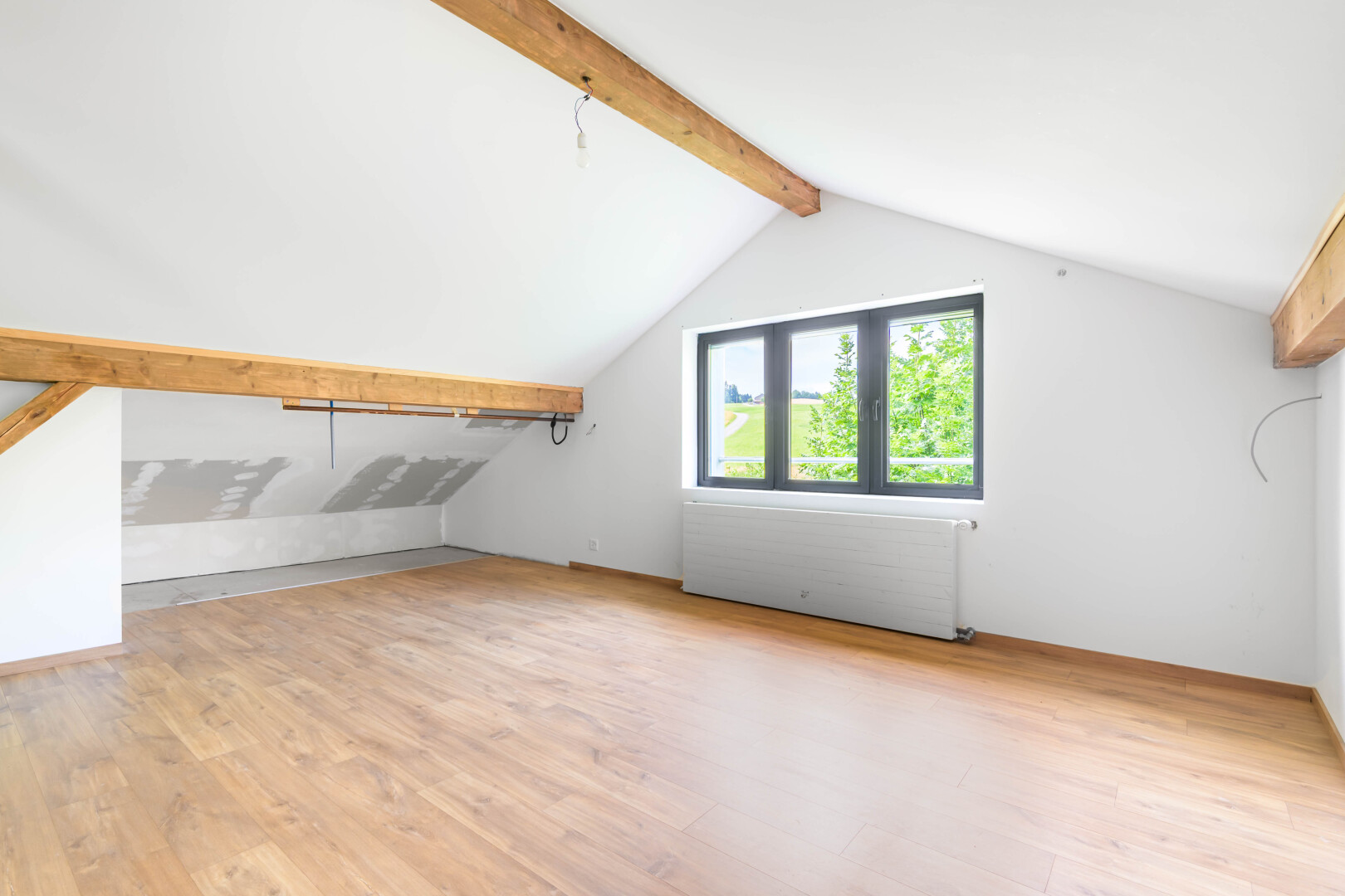 pièce vide avec beamed ceiling, plafond à poutres, wood finish floor, sol en finition bois, et vaulted ceiling