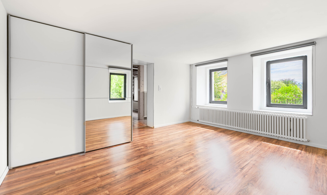 pièce vide avec radiateur, wood finish floor, sol en finition bois, natural light, et lumière naturelle