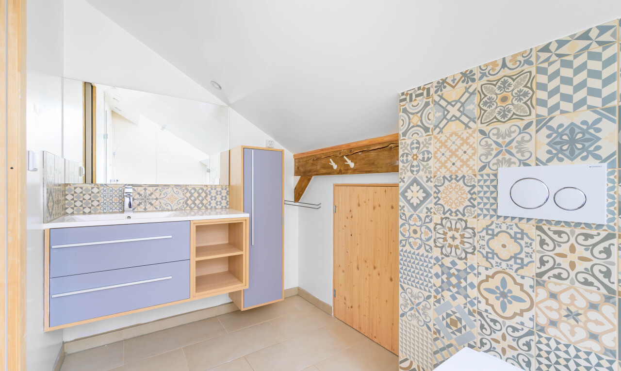 salle de bains avec vaulted ceiling, plafond voûté, lavabo (ou coiffeuse selon le contexte), inside property, et miroir