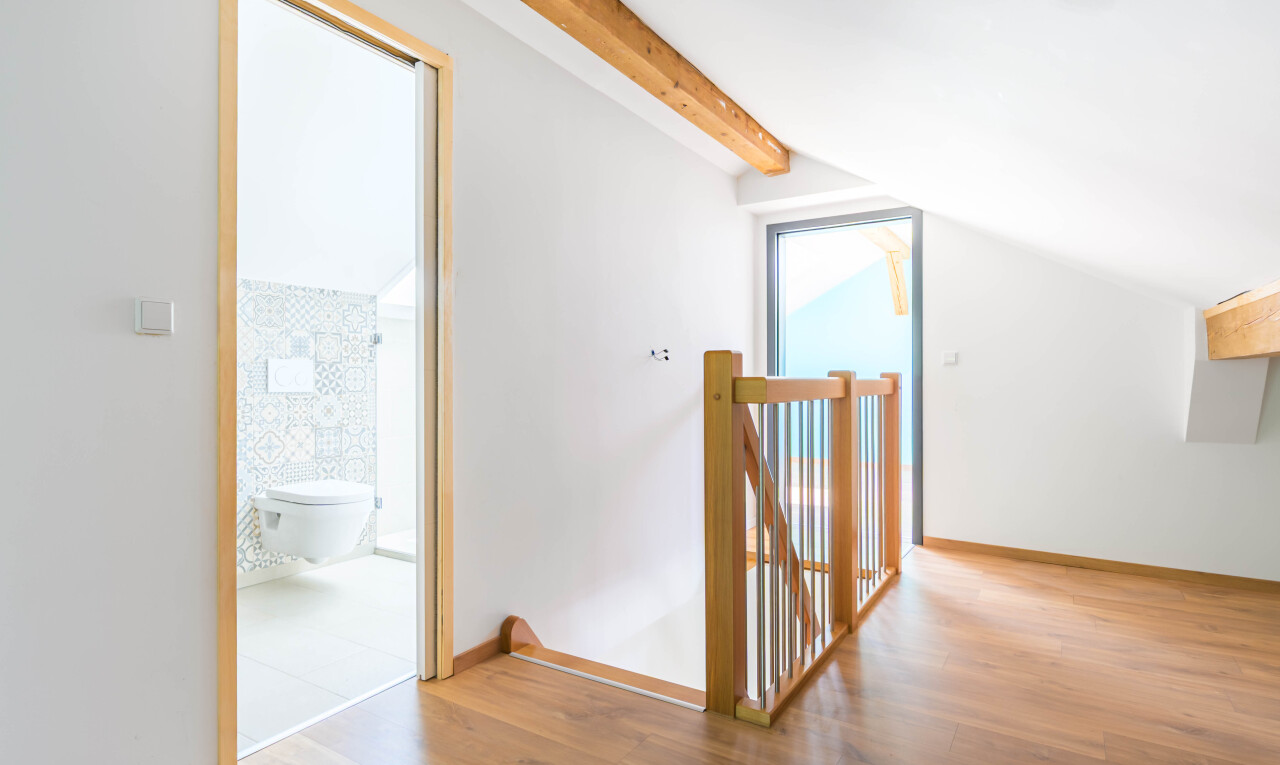 couloir avec wood finish floor, sol en finition bois, beamed ceiling, plafond à poutres, et vaulted ceiling