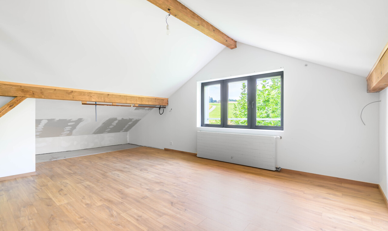 pièce vide avec beamed ceiling, plafond à poutres, wood finish floor, sol en finition bois, et vaulted ceiling