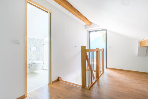 couloir avec wood finish floor, sol en finition bois, beamed ceiling, plafond à poutres, et vaulted ceiling