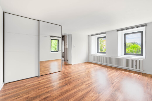 pièce vide avec radiateur, wood finish floor, sol en finition bois, natural light, et lumière naturelle
