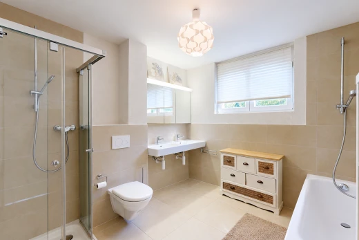 full bath with a stall shower, tile walls, and light tile patterned flooring