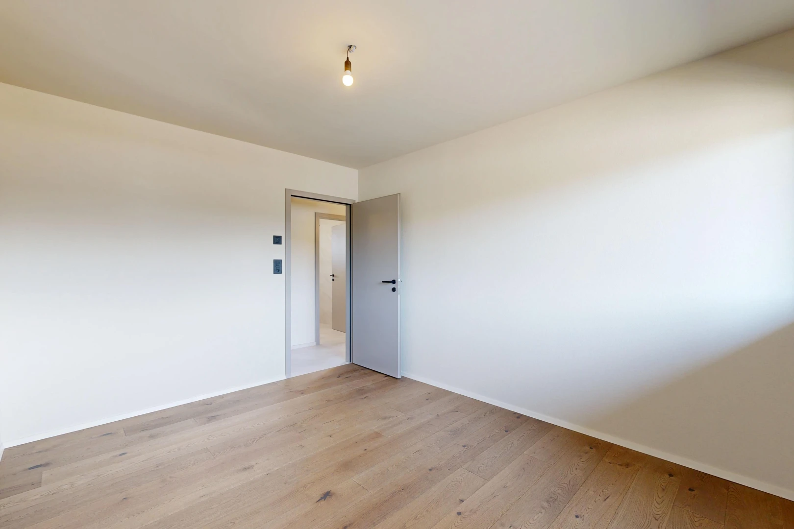 pièce vide avec cloison sèche, drywall, inside property, sol en finition bois, et wood finish floor