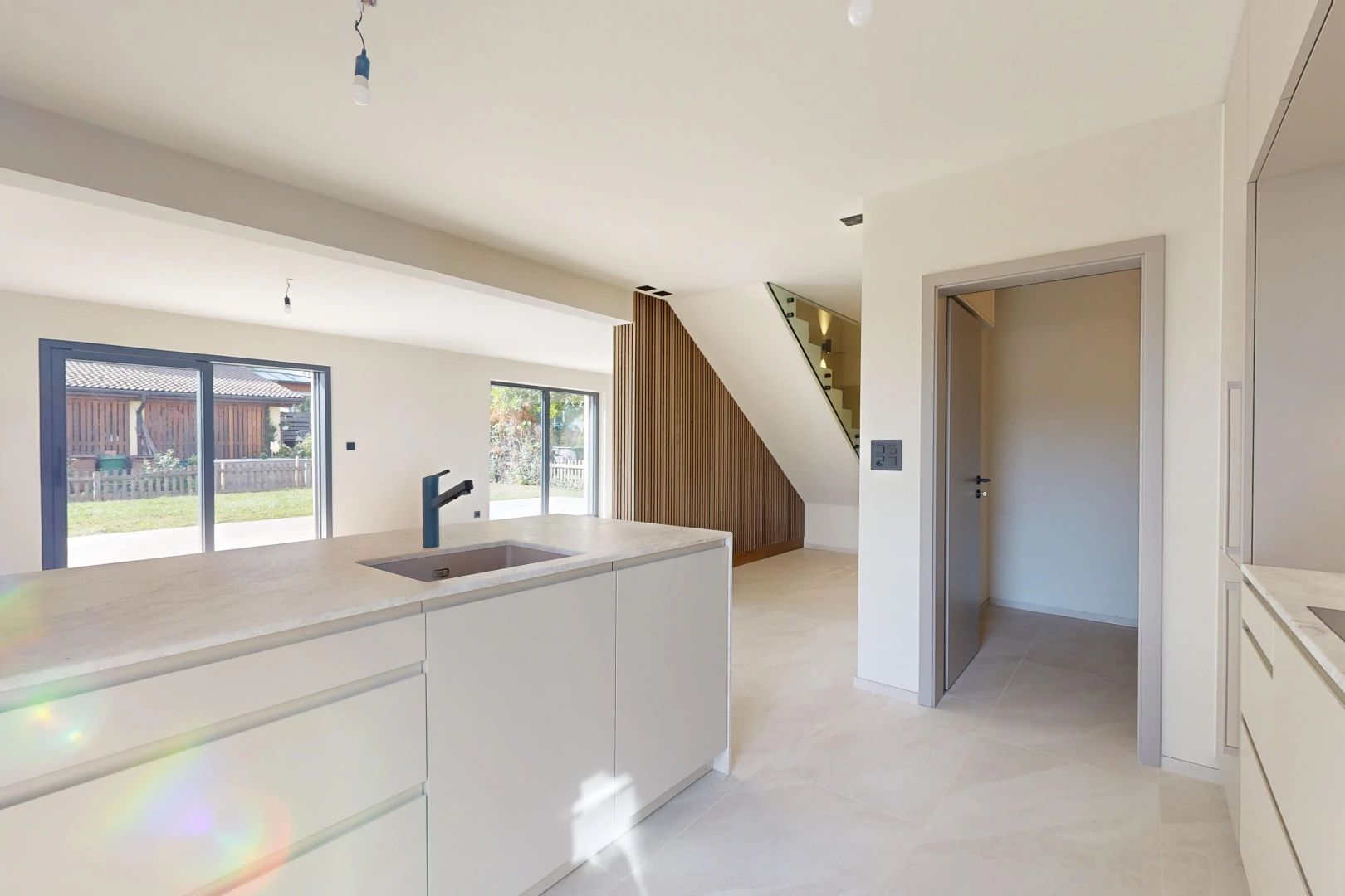 cuisine avec light countertops, light floor, drywall, cloison sèche, et évier