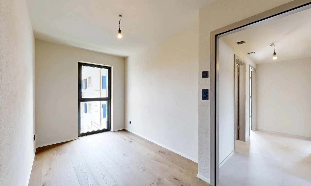 pièce vide avec éclairage suspendu, inside property, light floor, drywall, et cloison sèche
