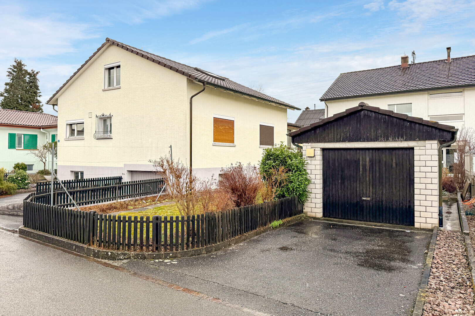 façade avec clôture, structure extérieure, day time, property visible, et garage
