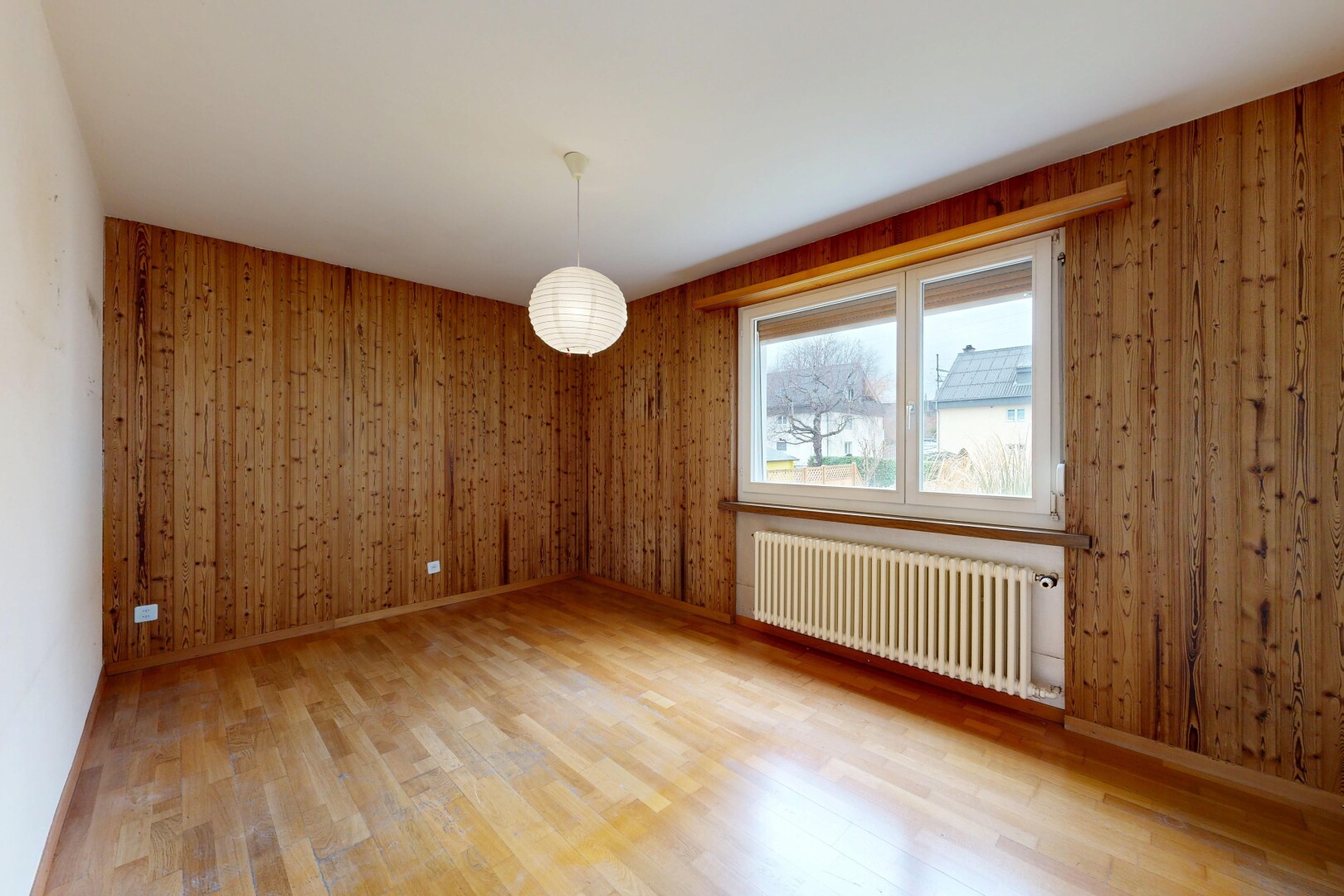 pièce vide avec radiateur, sol en finition bois, wood finish floor, mur en bois, et wood wall