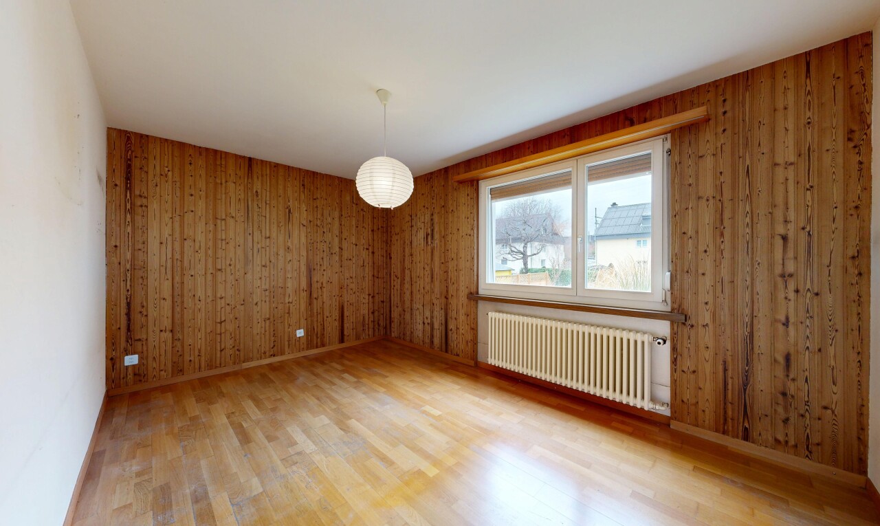pièce vide avec radiateur, sol en finition bois, wood finish floor, mur en bois, et wood wall