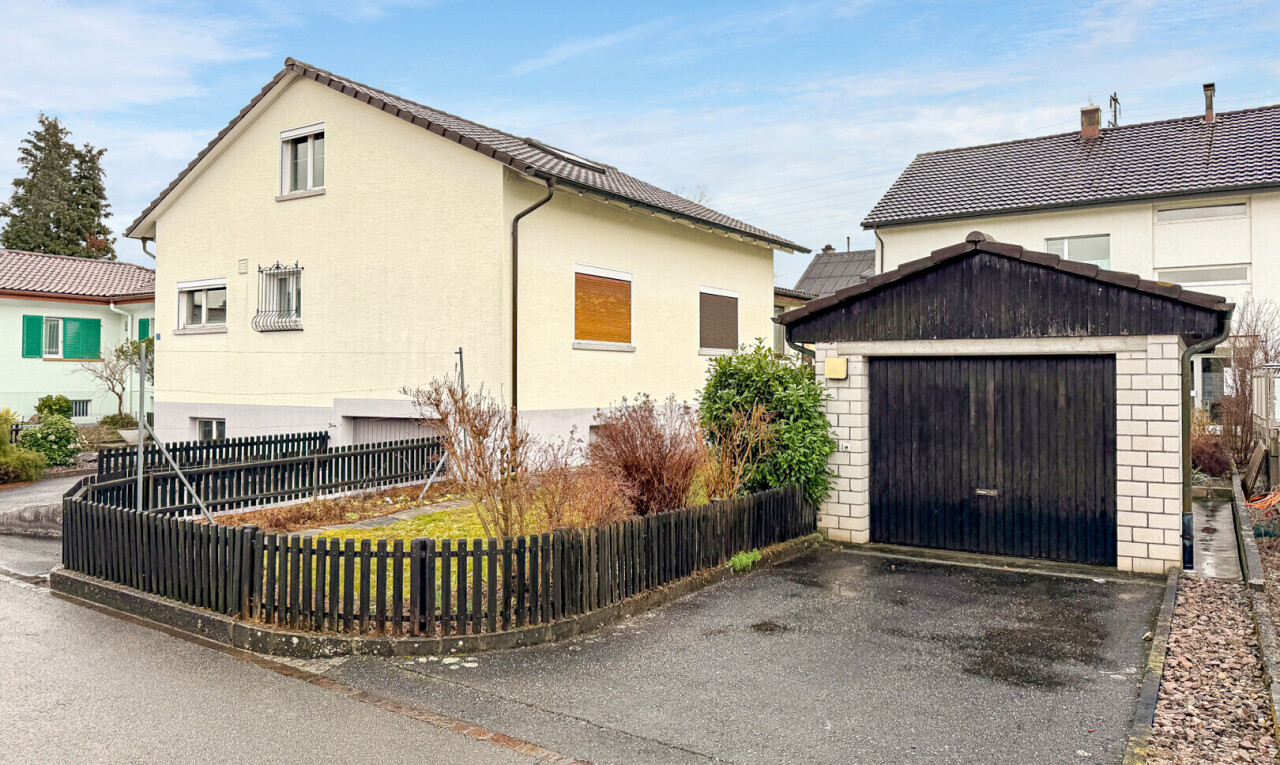 façade avec clôture, structure extérieure, day time, property visible, et garage