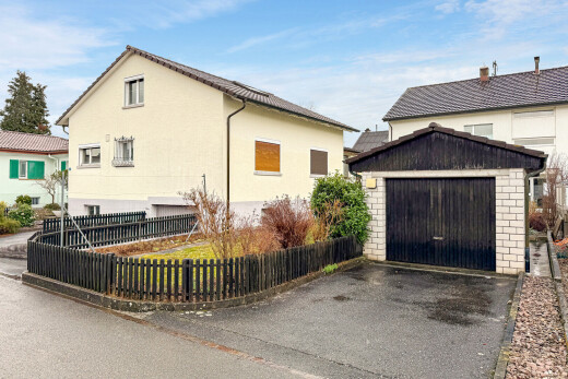 façade avec clôture, structure extérieure, day time, property visible, et garage