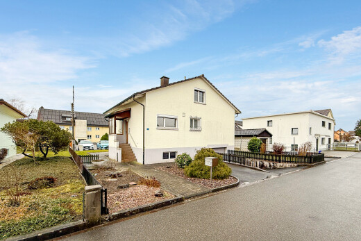 view of property with a garage and asphalt driveway