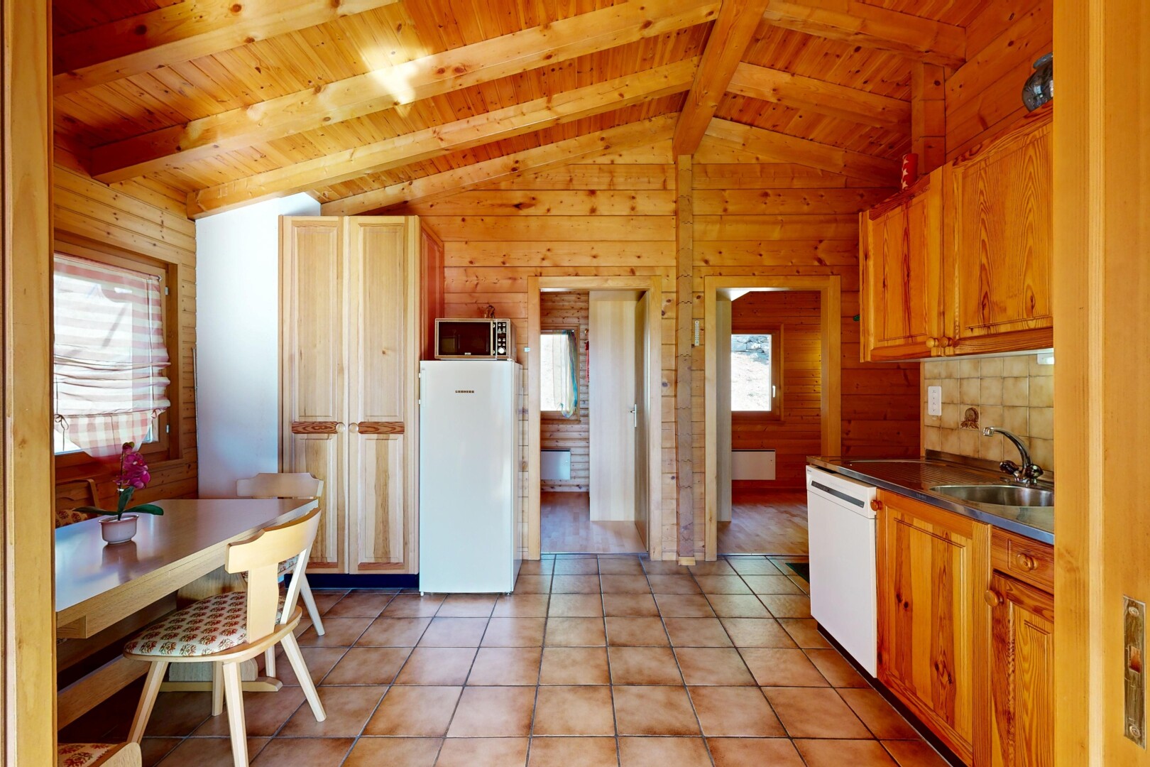 cuisine avec plafond en bois, wood ceiling, dated wood wall, dark countertops, et plans de travail
