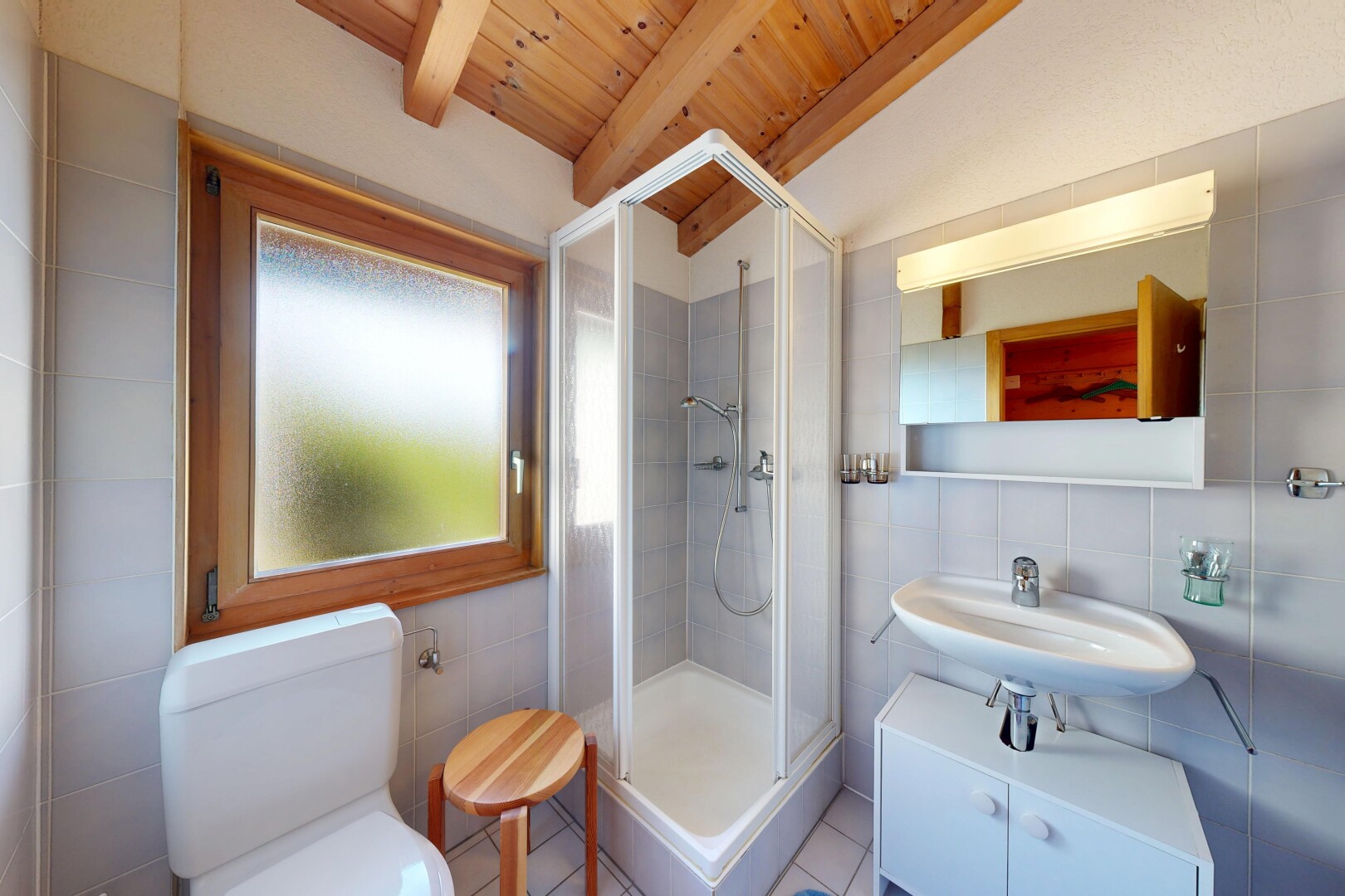 salle de bains avec beamed ceiling, plafond à poutres, miroir, douche, et vaulted ceiling