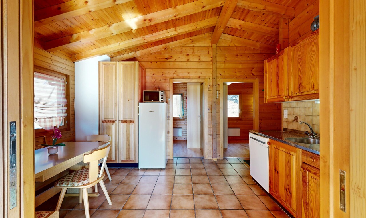 cuisine avec plafond en bois, wood ceiling, dated wood wall, dark countertops, et plans de travail
