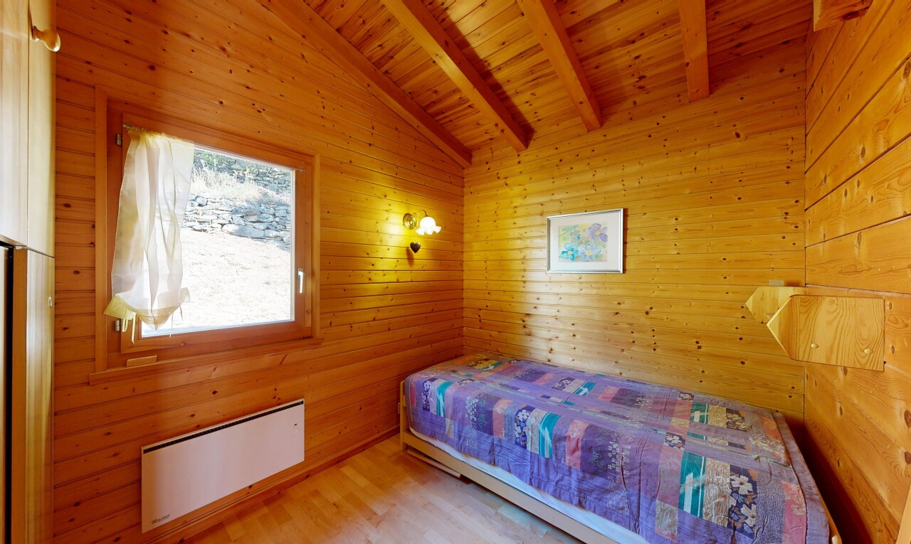 chambre avec beamed ceiling, plafond à poutres, vaulted ceiling, plafond voûté, et wood wall