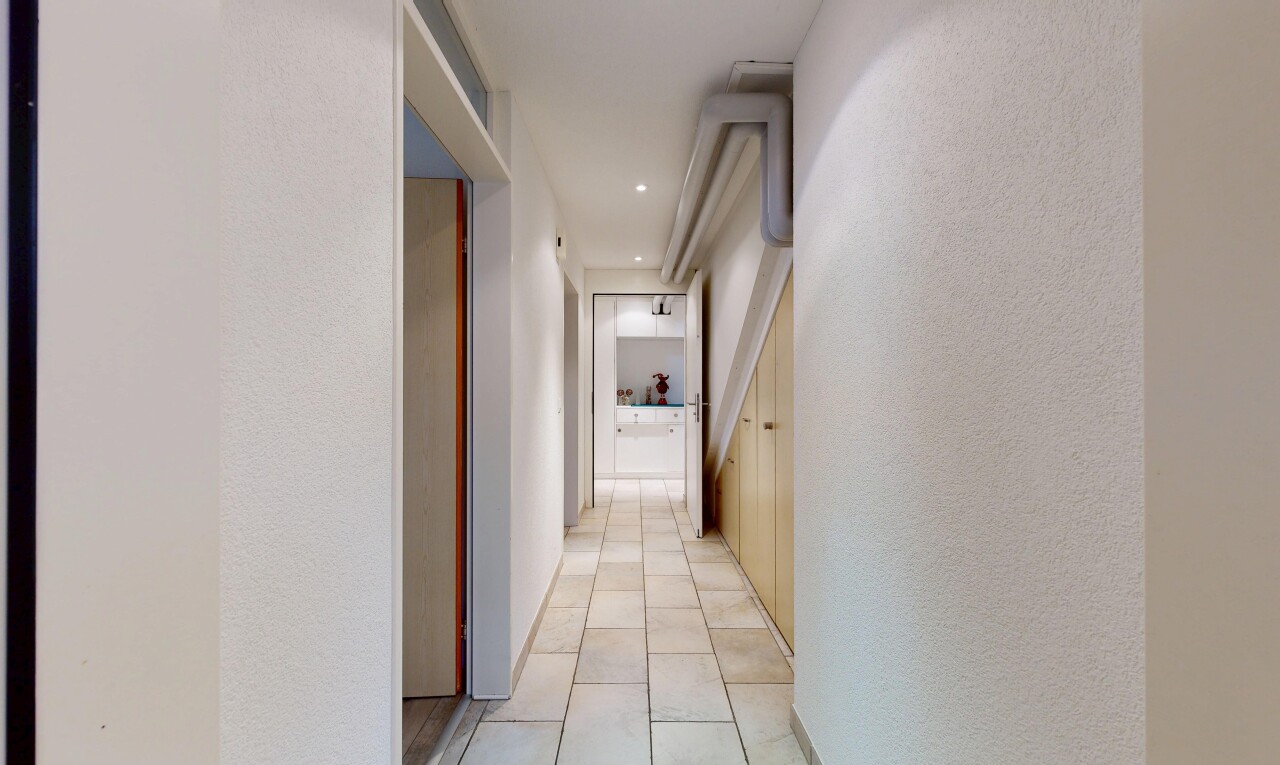 couloir avec inside property, sol en carrelage, tile floor, mur texturé, et textured wall