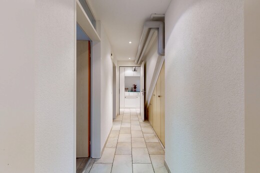 couloir avec inside property, sol en carrelage, tile floor, mur texturé, et textured wall