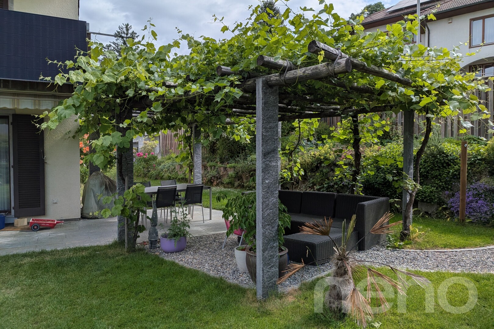 jardin avec terrasse, coin repas extérieur, pelouse, et espace de vie extérieur