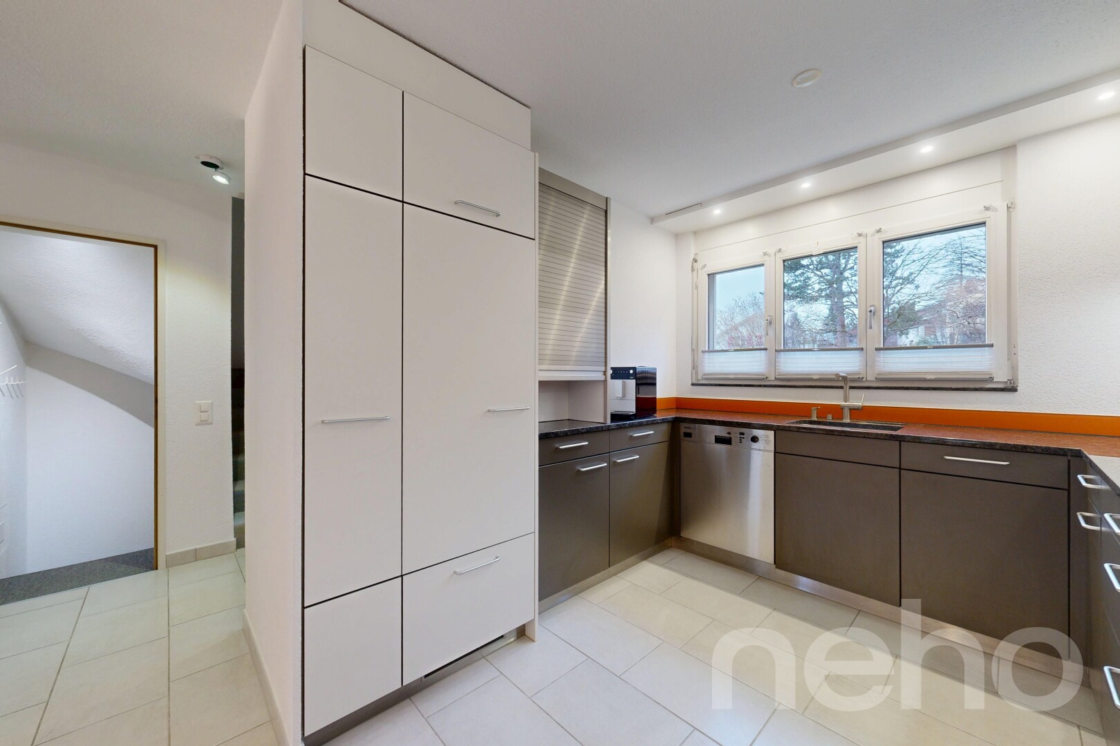cuisine avec dark countertops, plans de travail, drywall, cloison sèche, et light floor