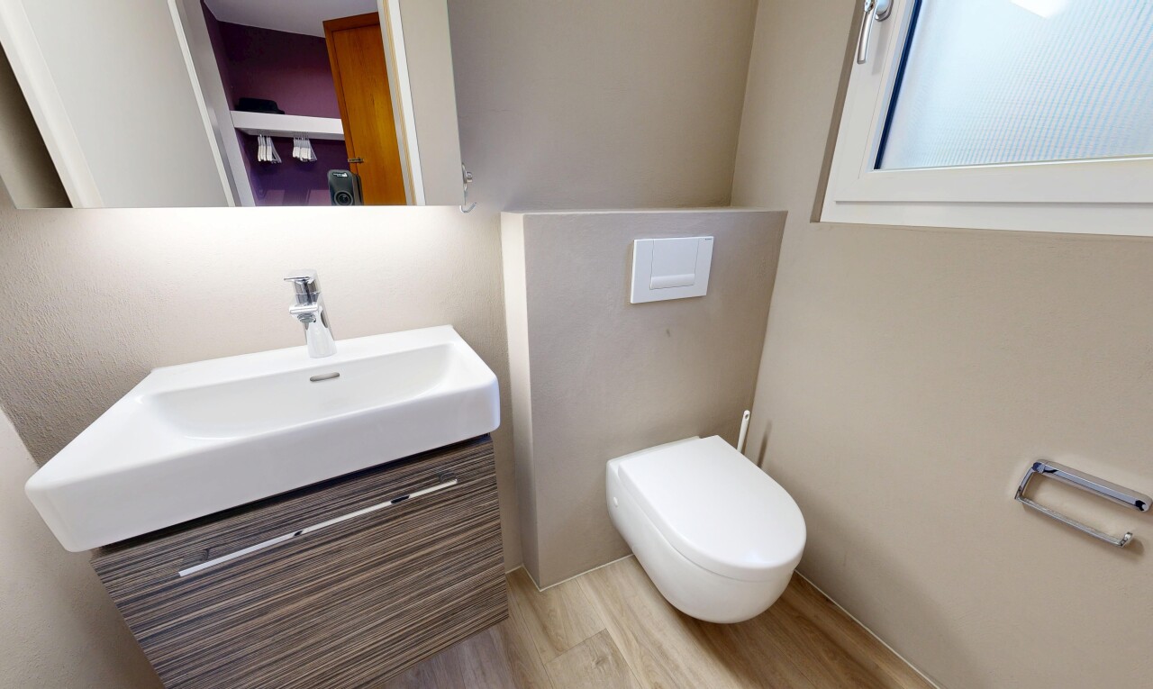 salle de bains avec miroir, inside property, lavabo (ou coiffeuse selon le contexte), toilette, et wood finish floor