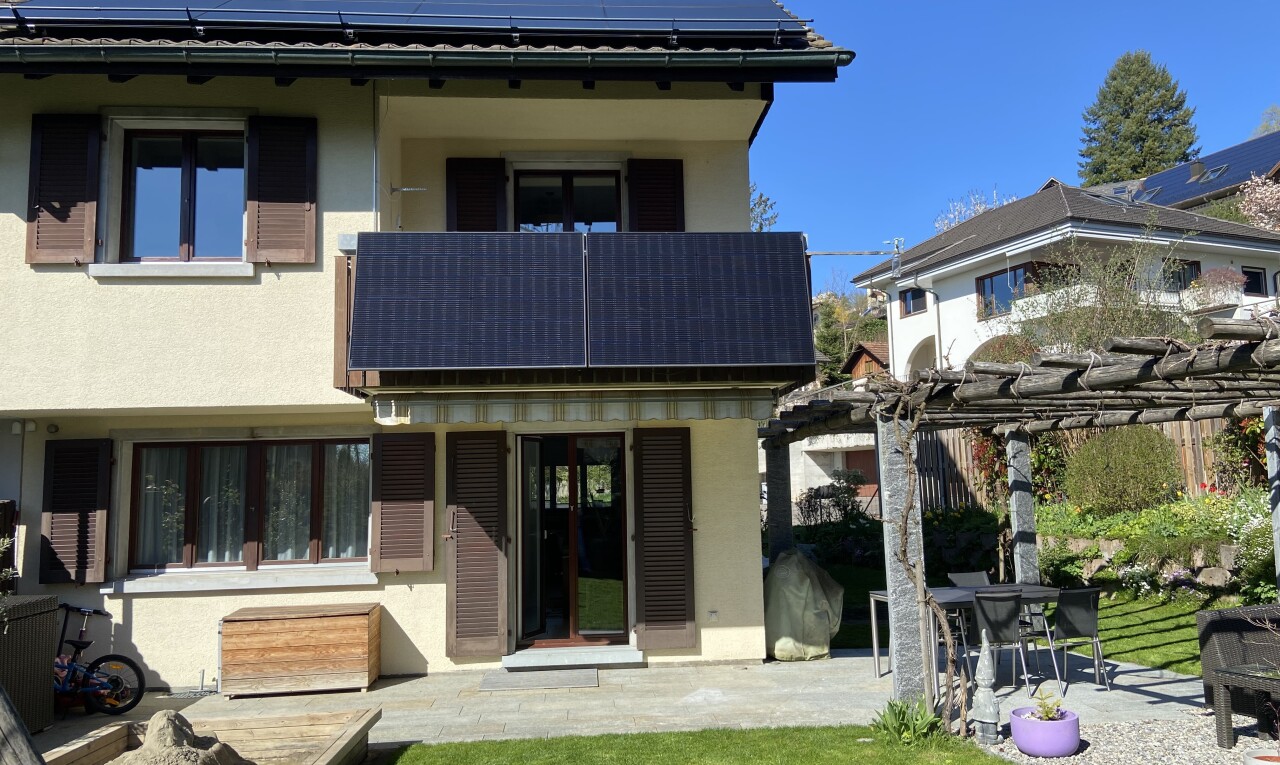 façade avec panneaux solaires, bardage en stuc, pergola, terrasse, et day time