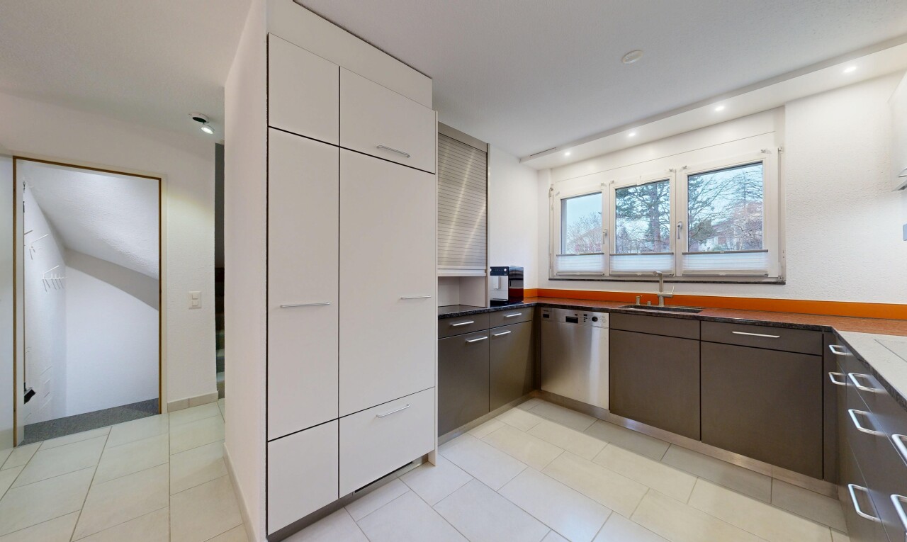 cuisine avec dark countertops, plans de travail, drywall, cloison sèche, et light floor