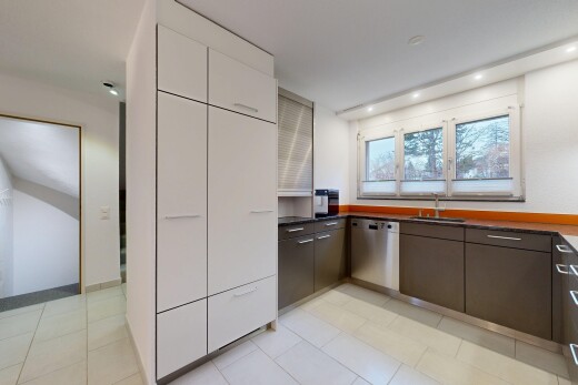 cuisine avec dark countertops, plans de travail, drywall, cloison sèche, et light floor