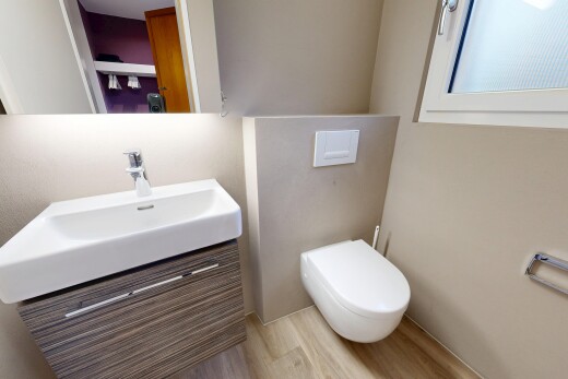 salle de bains avec miroir, inside property, lavabo (ou coiffeuse selon le contexte), toilette, et wood finish floor