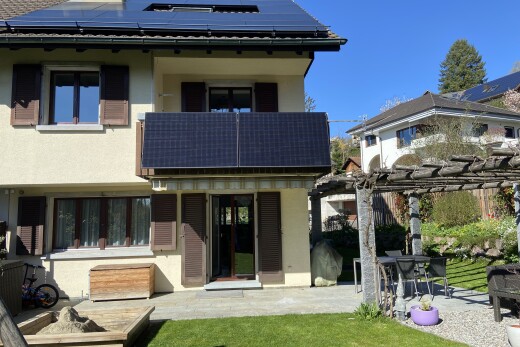 façade avec panneaux solaires, bardage en stuc, pergola, terrasse, et day time