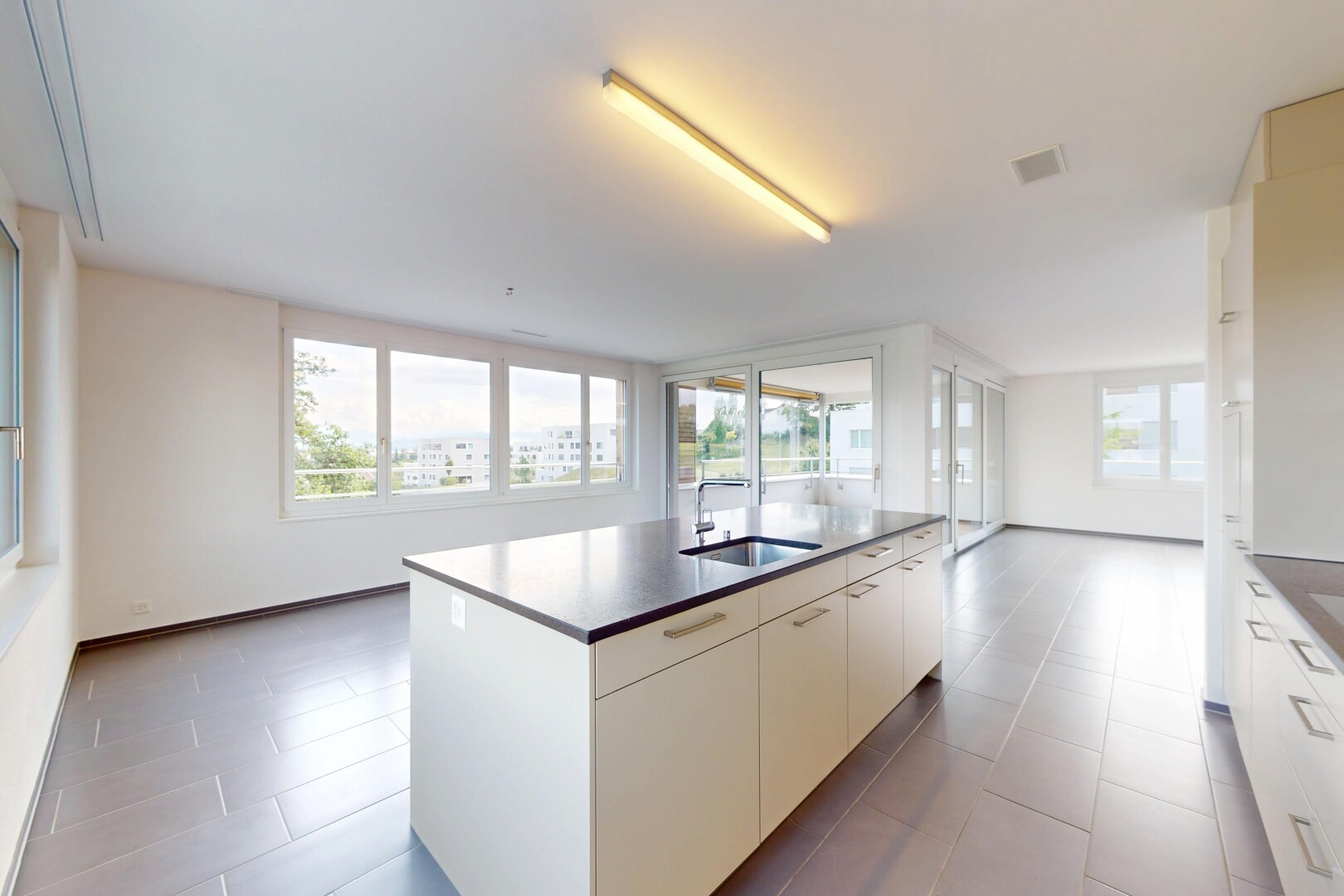cuisine avec natural light, lumière naturelle, îlot de cuisine, inside property, et évier