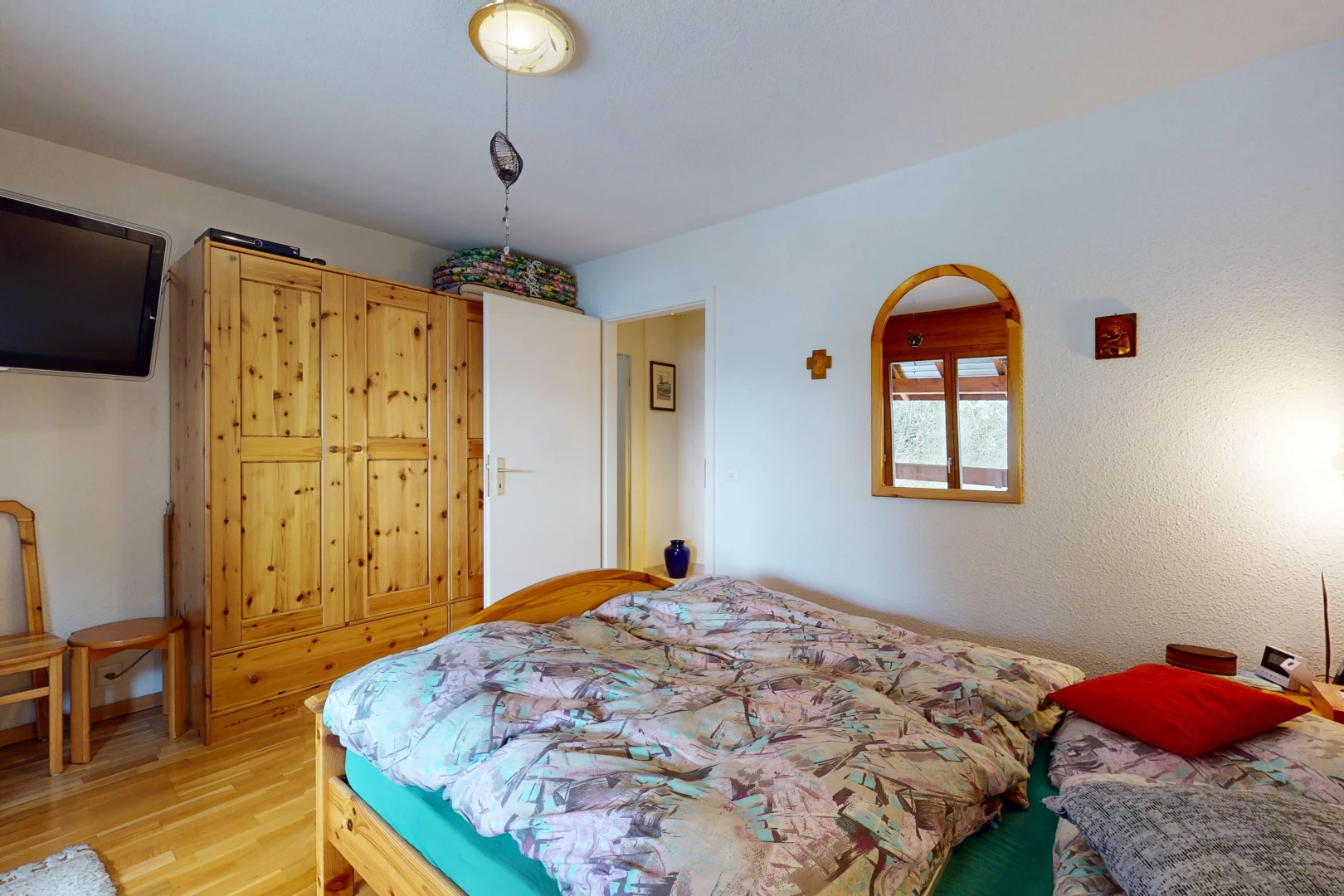 chambre avec lumière naturelle, plancher de bois, et télévision